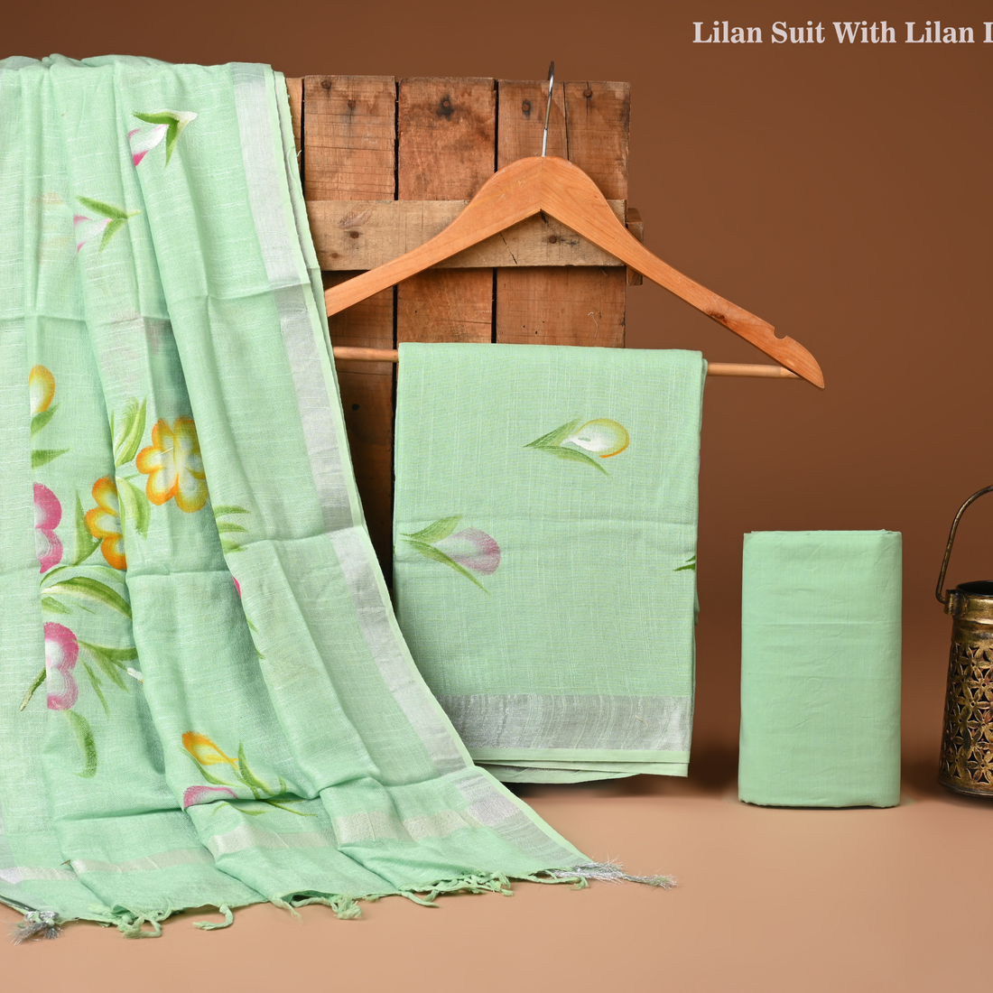 Green fabric with floral patterns on a wooden hanger against a brown background
