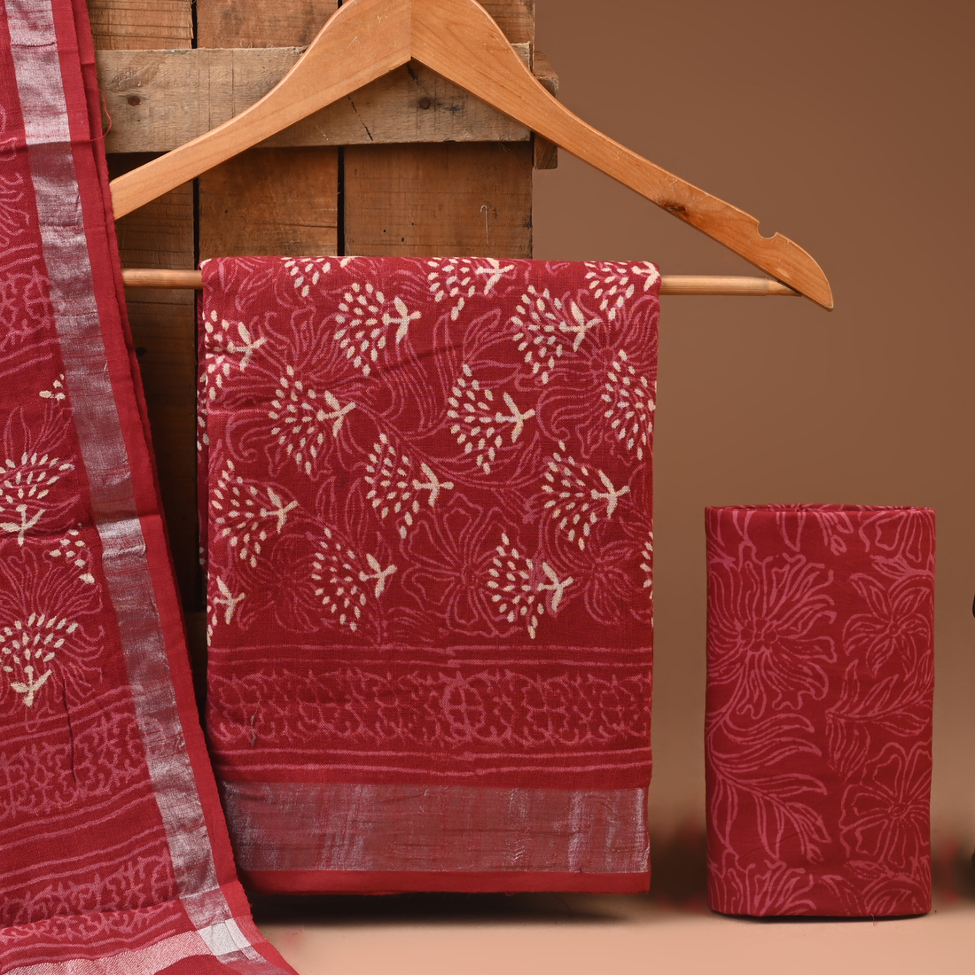 Red patterned fabric on a wooden hanger against a brown background