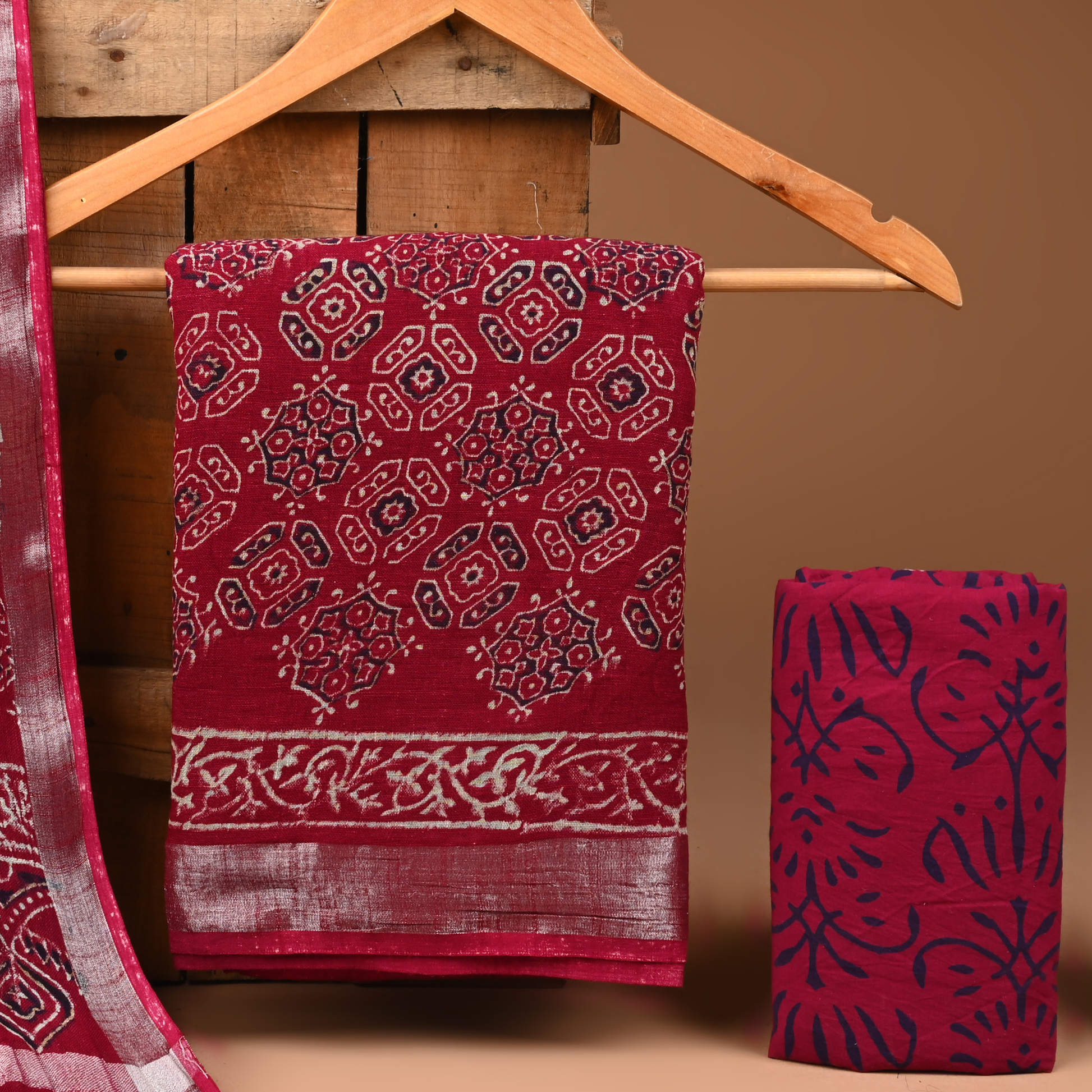Red patterned fabric on a wooden hanger against a brown background